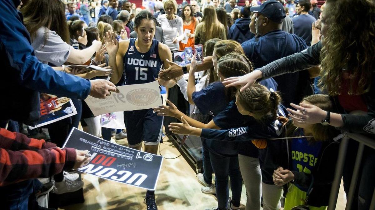 Connecticut's Gabby Williams (15) high-fives fans as she leaves the court after an 88-48 victory against SMU at Moody Coliseum in Dallas on Saturday. With the victory, UConn broke its own NCAA record with its 91st consecutive win.