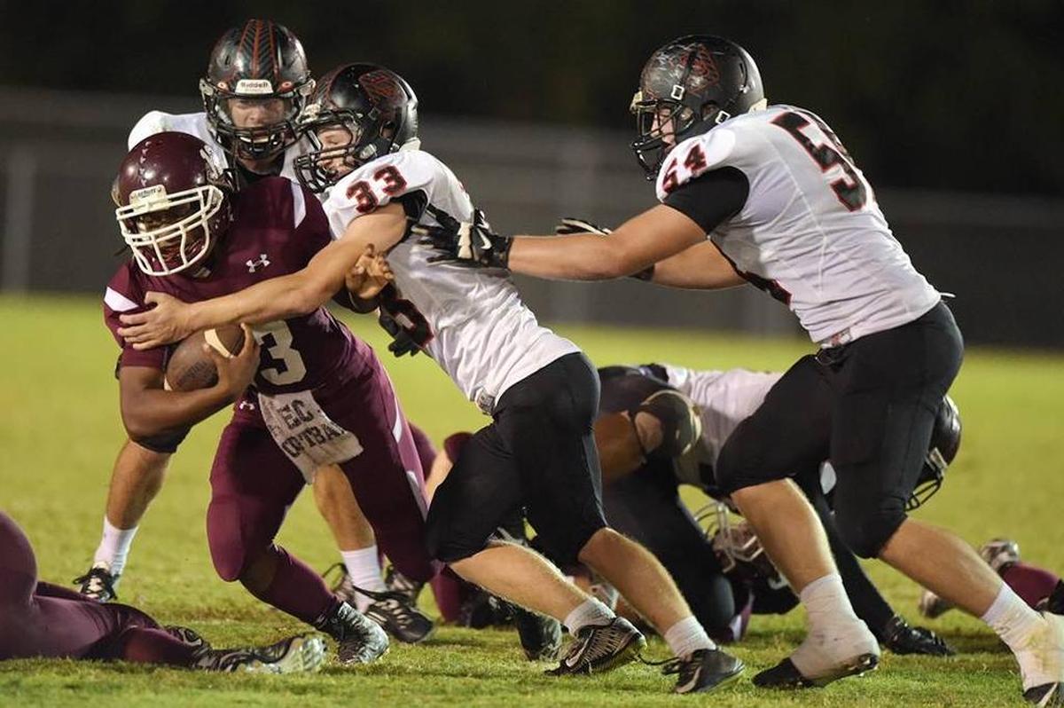 East Central tailback Jessie Bradley (13) is tackled by St. Stanislaus linebacker Ricky Schaefer (33) and defensive end Tommy Reeder (54) during the second quarter, Friday, Oct. 16 2015, in Hurley.
