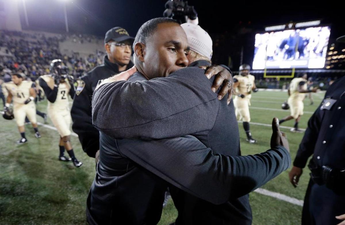 Vanderbilt head coach Derek Mason, left, hugs Kentucky head coach Mark Stoops after an NCAA college football game Saturday, Nov. 14, 2015, in Nashville, Tenn. Vanderbilt won 21-17.