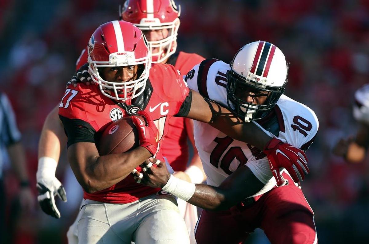 FILE - In this Sept. 19, 2015, file photo, Georgia running back Nick Chubb (27) tries to break free from South Carolina linebacker Skai Moore (10) during the first half of an NCAA college football game in Athens, Ga. No. 13 Alabama takes on No. 8 Georgia on Saturday in Tuscaloosa.