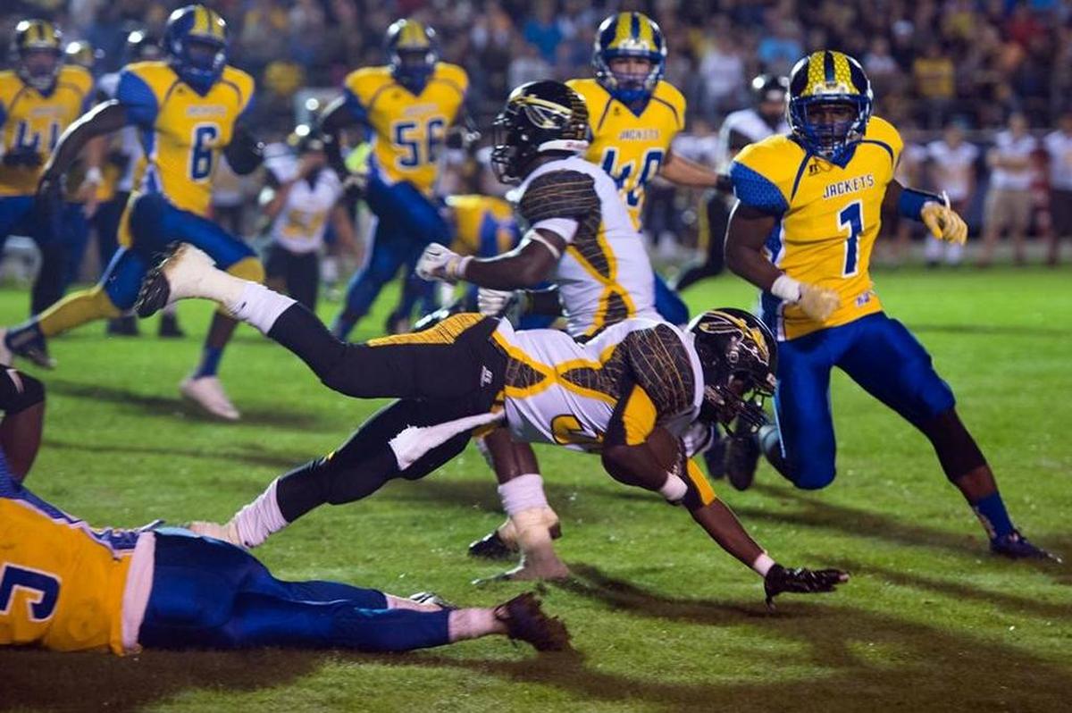 D'Iberville's Ja'quavis Foster dives over a St. Martin defender during a the 2015 showdown at St. Martin.