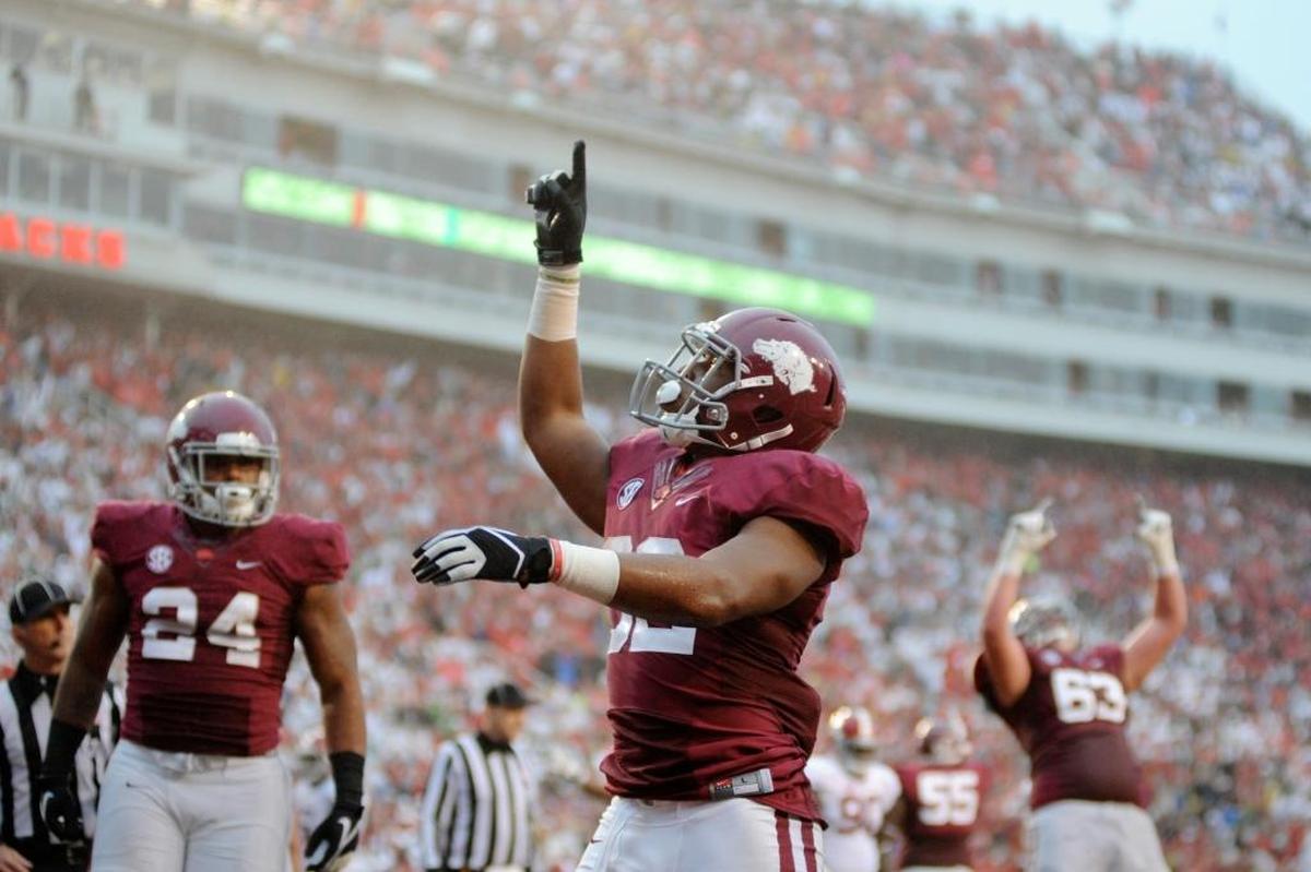 Arkansas running back Jonathan Williams, center, celebrates his first half touchdown with teammates fullback Kody Walker (24) and offensive tackle Dan Skipper (63) in the second quarter of an NCAA college football game in Fayetteville, Ark., Saturday, Oct. 11, 2014.