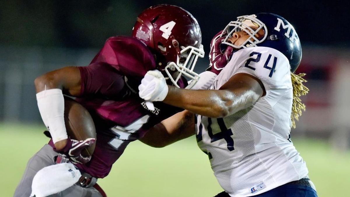 East Central running back Tony Brown (4) tries to runs against Moss Point outside linebacker Jalin Stallworth (24) in the second quarter, Friday, Sept. 29, 2017, at East Central High School in Hurley.