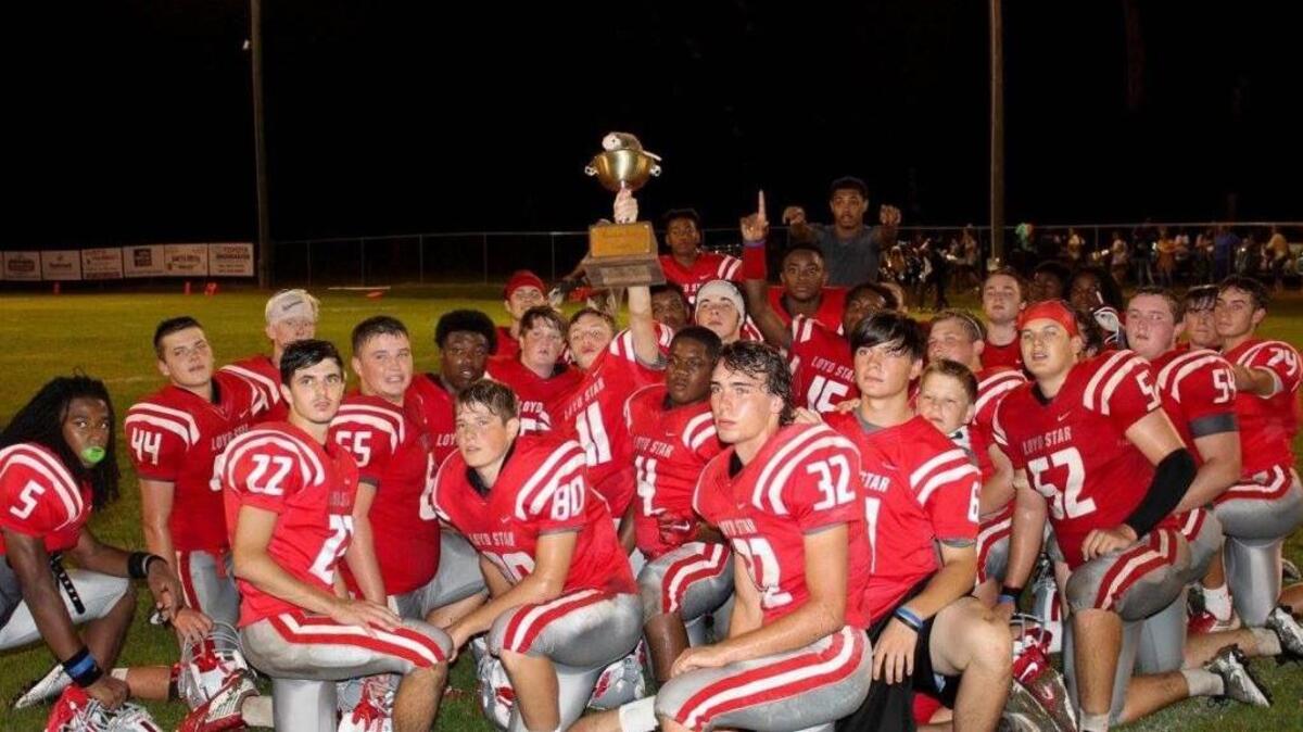Proud Loyd Star players show off Possum Bowl trophy.