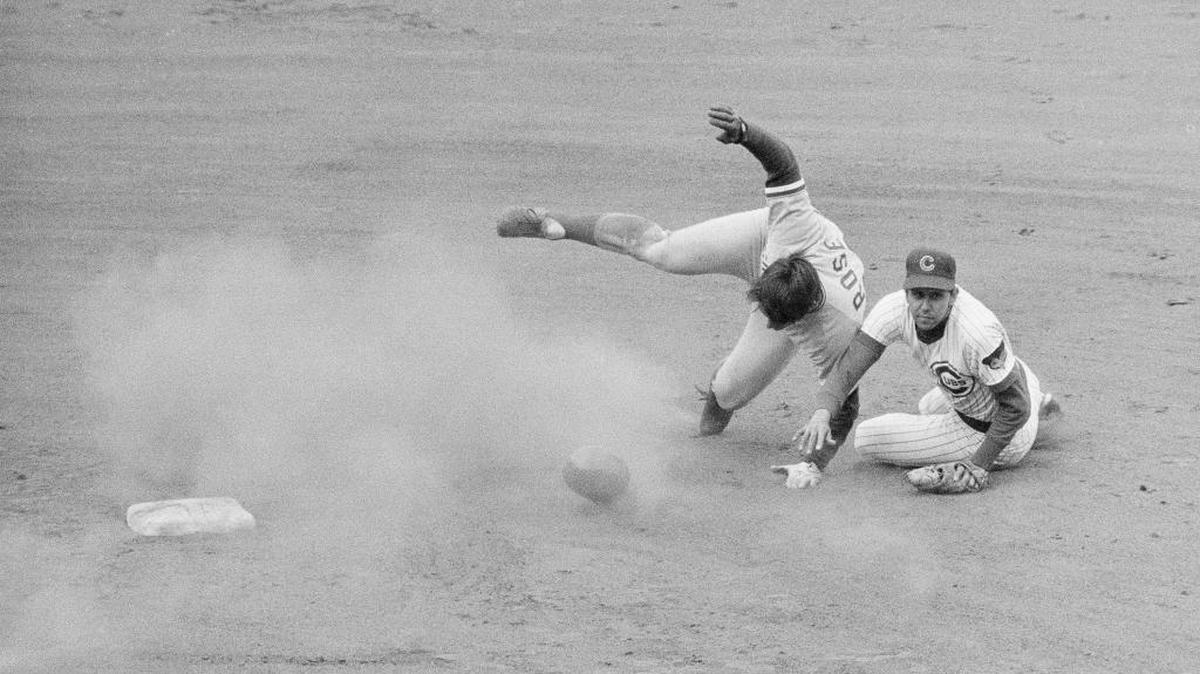 Cincinnati Reds outfielder Pete Rose, left, tumbles over after being forced out at second base in the seventh inning against the Cubs in Chicago on Sunday, May 1, 1972. Cubs shortstop Don Kessinger looks toward first base to see if his throw was quick enough to catch Reds outfielder Bobby Tolan who batted in to the play. Kessinger wasn't fast enough with the toss, but Chicago took the win 6-4, anyway.