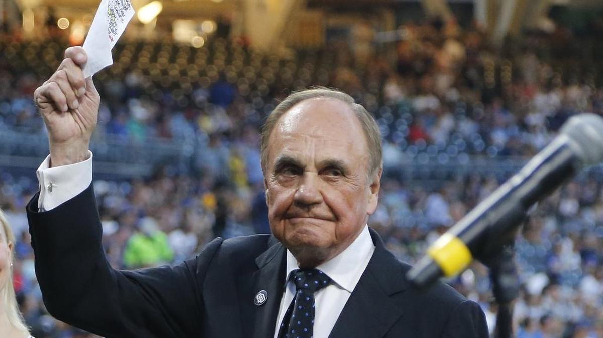 Former San Diego Padres broadcaster Dick Enberg waves to crowd at a retirement ceremony prior to the Padres' final home baseball game of the season, against the Los Angeles Dodgers in San Diego. Enberg, the sportscaster who got his big break with UCLA basketball and went on to call Super Bowls, Olympics, Final Fours and Angels and Padres baseball games, died Dec. 21, 2017. He was 82.