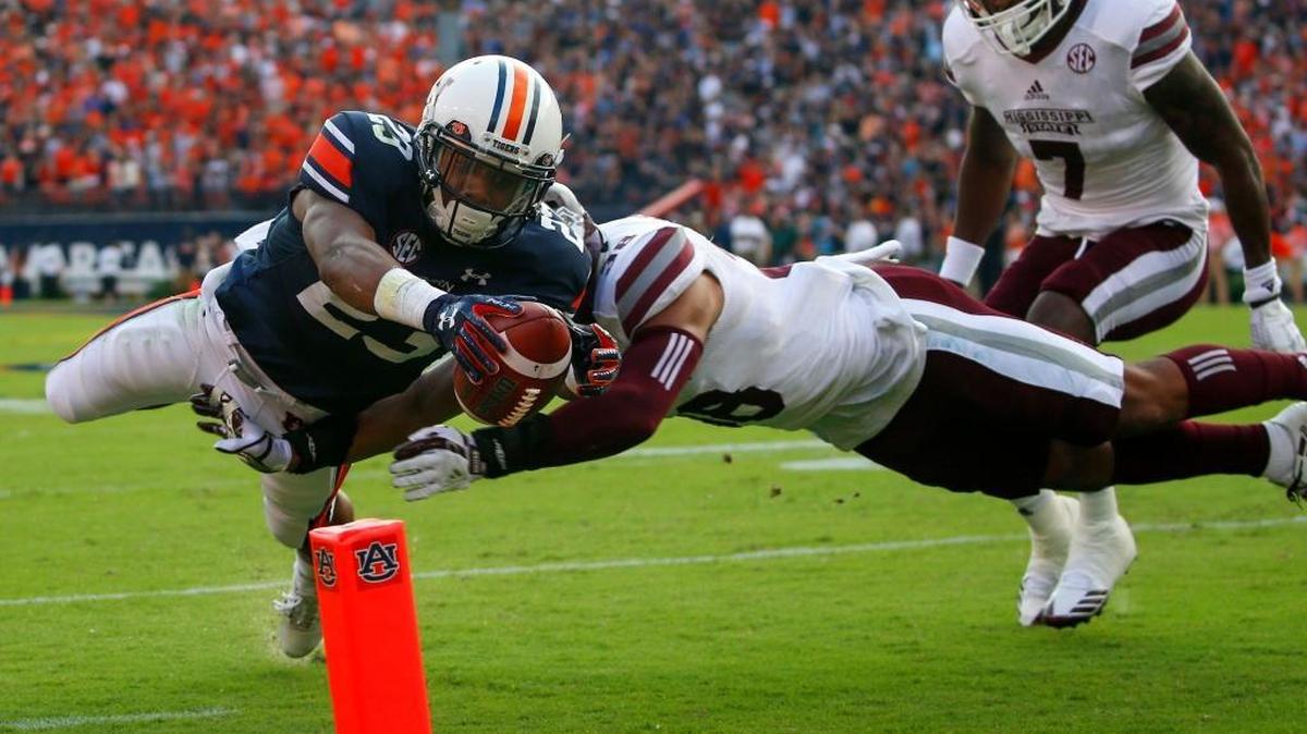 Auburn wide receiver Ryan Davis (23) dives past Mississippi State defensive back Johnathan Abram (38) into the end zone for a touchdown during the first half of an NCAA college football game, Saturday, Sept. 30, 2017, in Auburn, Ala.