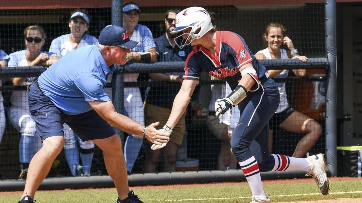 Ole Miss’ Brittany Finney, right, is congratulated by coach Mike Smith following her two-run home run against North Carolina during the NCAA Regional in Oxford on Sunday.
